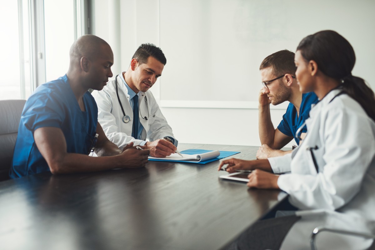 healthcare professionals sitting at a table calculating risk adjustment